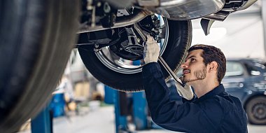 Technik na stanici technické kontroly prohlíží ojetý vůz